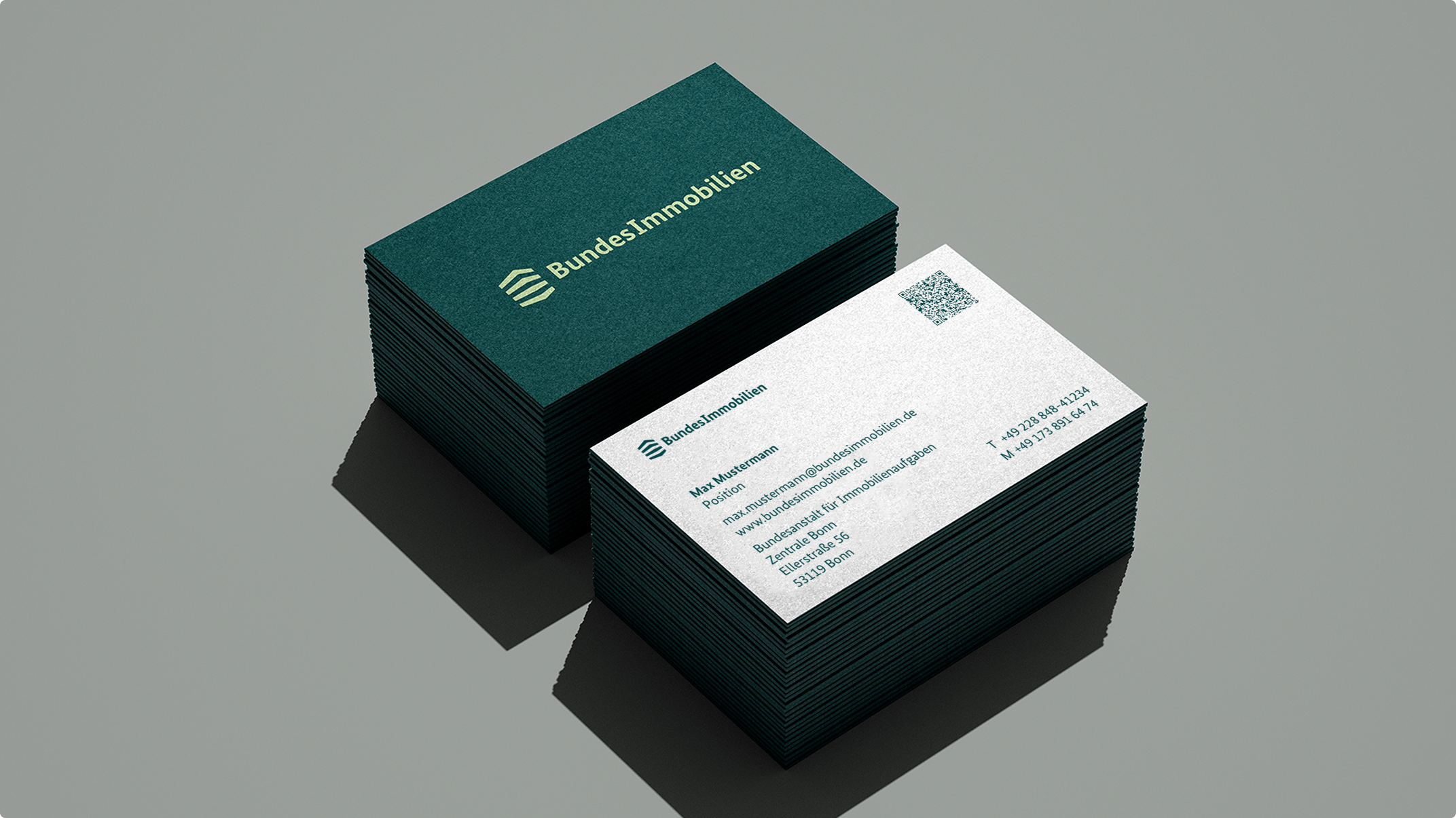 Zwei Stapel von Visitenkarten der Bundesimmobilien. Eine Karte zeigt das Logo und Kontaktdaten, die andere die Rückseite mit dem Logo.