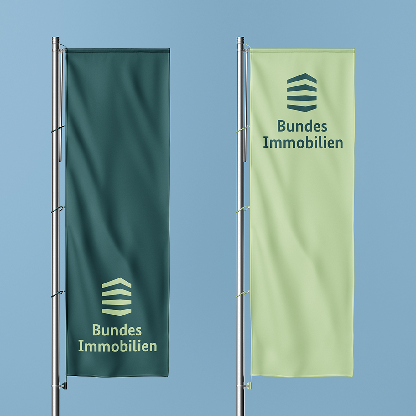 Zwei Fahnen mit dem Logo von Bundesimmobilien, eine dunkelgrün und eine hellgrün.