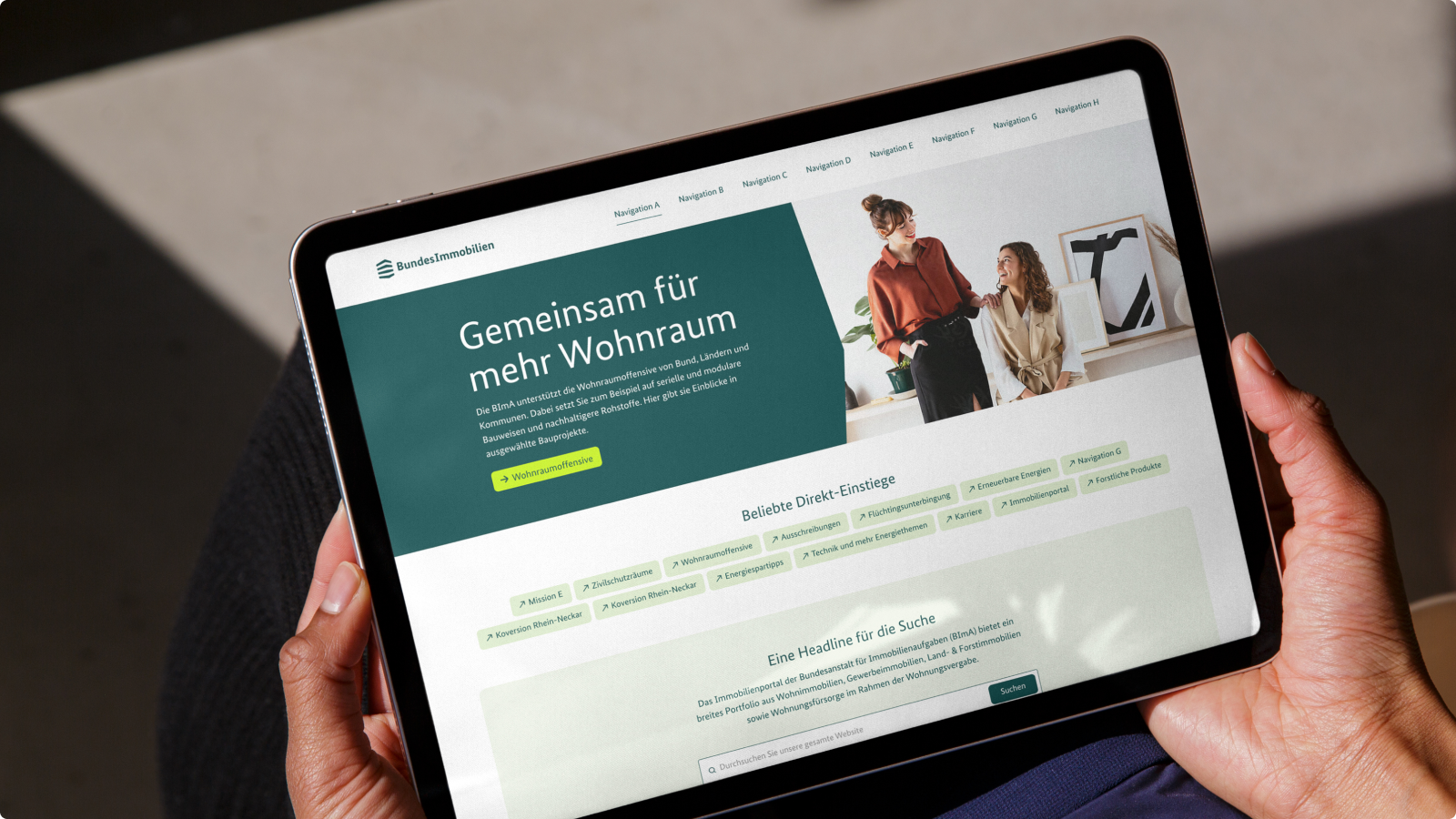 Eine Person hält ein Tablet, das die Bundesimmobilien-Website Website zeigt.