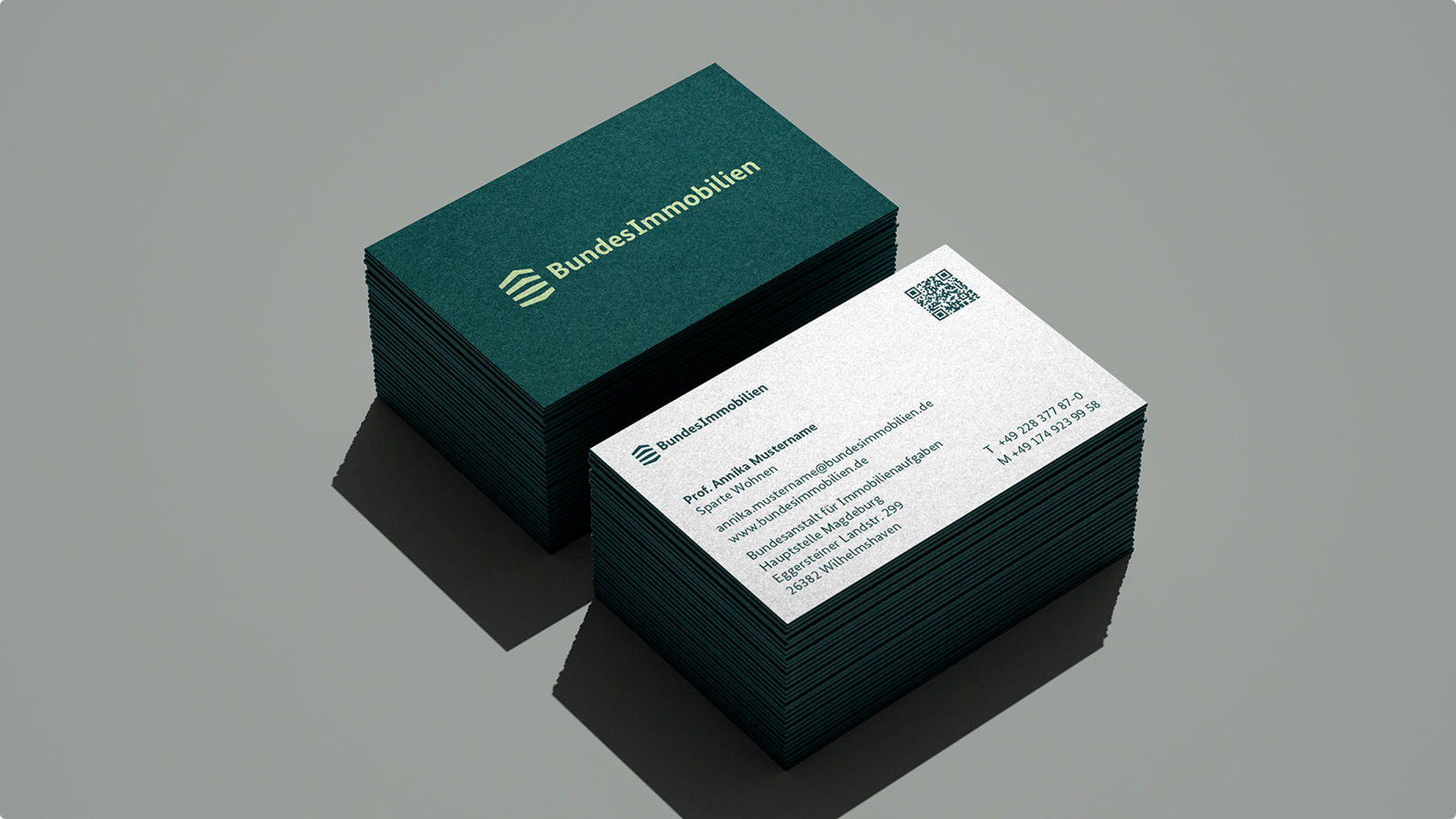 Zwei Stapel von Visitenkarten der Bundesimmobilien. Eine Karte zeigt das Logo und Kontaktdaten, die andere die Rückseite mit dem Logo.